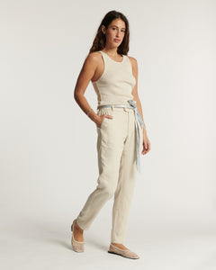 Jean femme en toile légère couleur écume, coupe droite ajustée avec ceinture fine nouée, offrant un confort estival élégant et facile à porter.