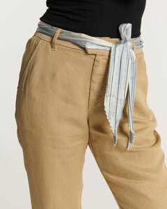 Pantalon en tissu Tencel couleur praline, coupe droite et confortable avec ceinture nouée rayée bleue et blanche, idéal pour un style décontracté féminin.