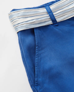 Jean femme en tissu tencel bleu outre-mer, coupe droite ajustée avec texture douce et ceinture rayée blanche et bleue pour une touche estivale élégante.