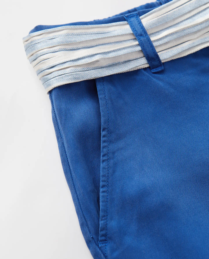 Jean femme en tissu tencel bleu outre-mer, coupe droite ajustée avec texture douce et ceinture rayée blanche et bleue pour une touche estivale élégante.