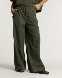 Pantalon fluide en popeline kaki, coupe large et droite, matière légère et adaptée aux morphologies féminines, offrant confort et élégance décontractée.