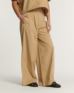 Pantalon large en popeline couleur praline, matière légère et fluide, coupe décontractée avec taille élastique, parfait pour un style estival féminin et confortable.