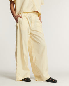 Pantalon large en popeline de coton couleur vanille, coupe fluide et décontractée avec taille élastique, idéal pour un style d'été léger et confortable.