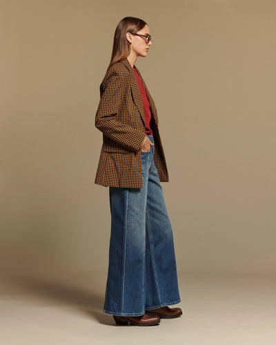 Jean large en denim bleu 100% coton avec une coupe évasée et taille moyenne, alliant confort et style décontracté pour femme.