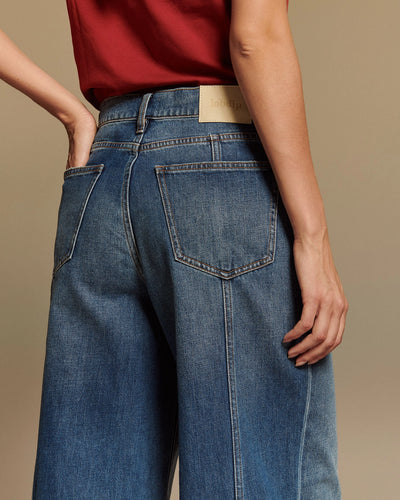 Jean large en denim 100% coton bleu moyen avec coupe droite et taille moyenne, offrant un ajustement confortable et s’adaptant à toutes les morphologies féminines.