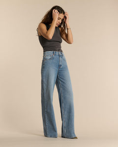 Jean femme en denim bleu clair 100 % coton, coupe droite et ample, matière confortable et adaptée à toutes les morphologies pour un style décontracté.