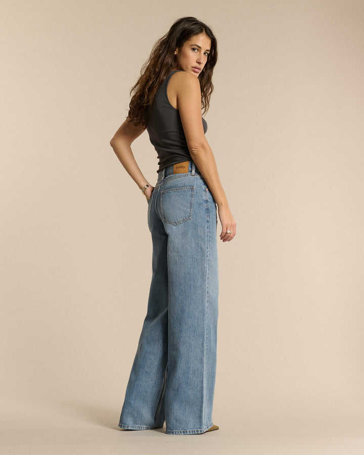 Jean en denim bleu clair, coupe large et fluide, matière en coton 100% avec une silhouette décontractée qui s’adapte à toutes les morphologies féminines.