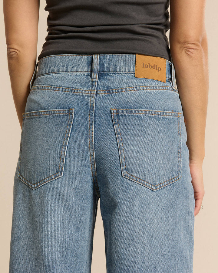 Jean en denim bleu clair 100 % coton avec coupe large et taille haute, s'adaptant confortablement à toutes les morphologies féminines.